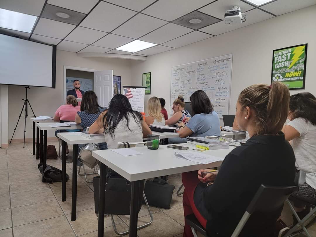 Instructor enseñando frente a un grupo de estudiantes en el salón